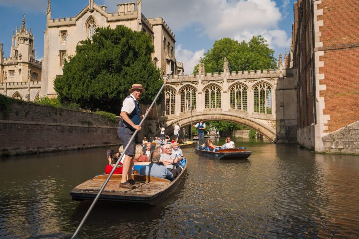 a person riding on the back of a boat next to a river