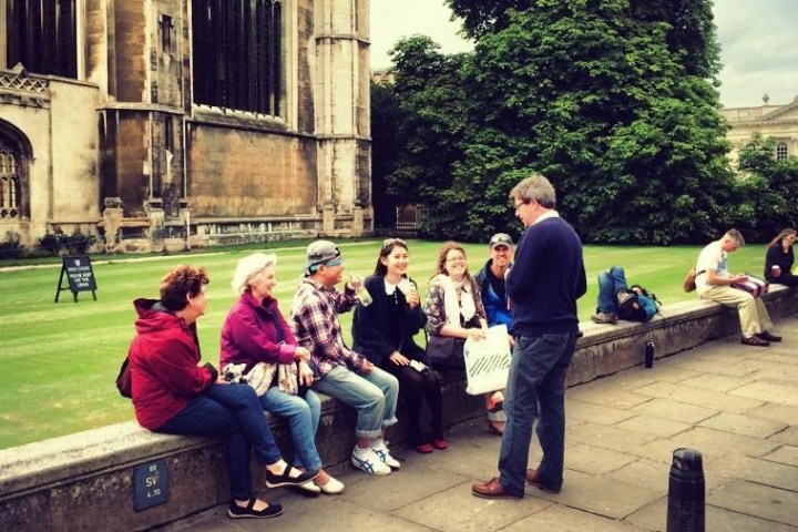 a group of people sitting on a bench in front of a building